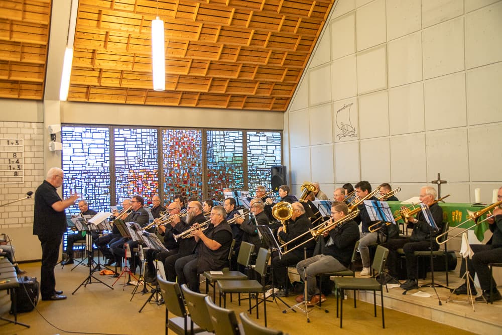 Der Posaunenchor Haßloch bei einem Gottesdienst, Chorleiter dirigiert das Ensemble